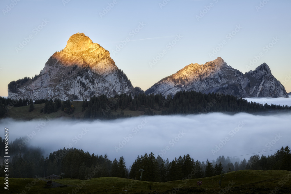 Fototapeta premium Aufgehende Sonne, Grosser und kleiner Mythen, Schweizer Berge, über Nebelmeer