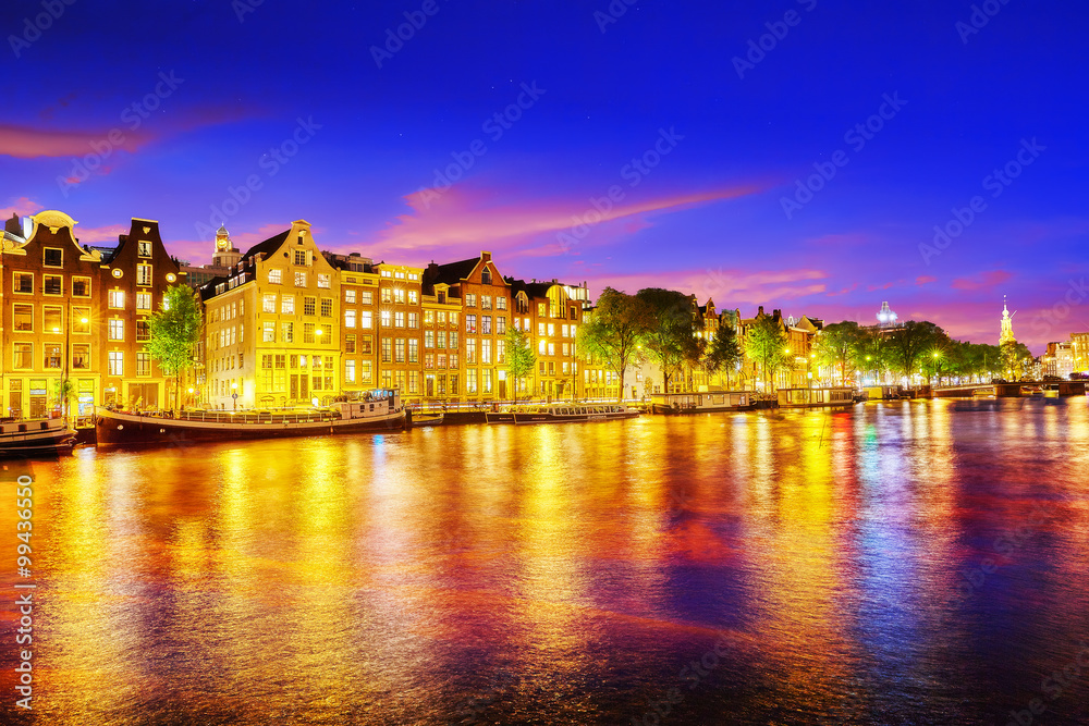 Famous Amstel river and night view of beautiful Amsterdam city.