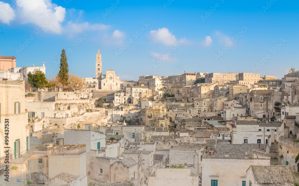 panoramic view of typical stones (Sassi di Matera) and church of Matera UNESCO European Capital of Culture 2019 under blue sky