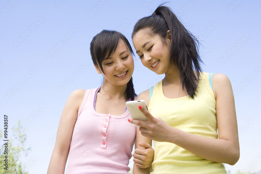 Two young women with a mobile phone Two young women with a mobile phone