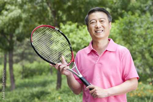 Senior man playing tennis in park © Blue Jean Images