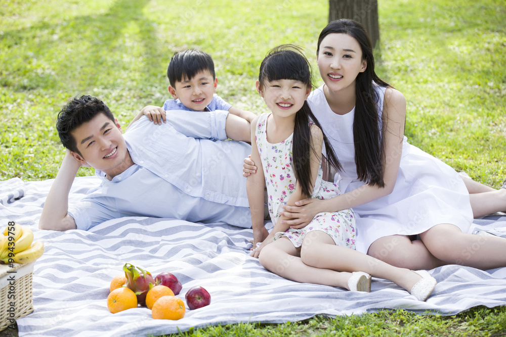 Happy young family having picnic on grass Happy young family having picnic on grass