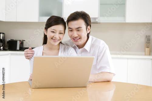 Young couple using a laptop at home