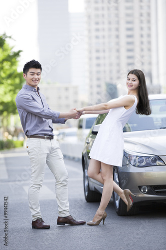 Happy young couple and car