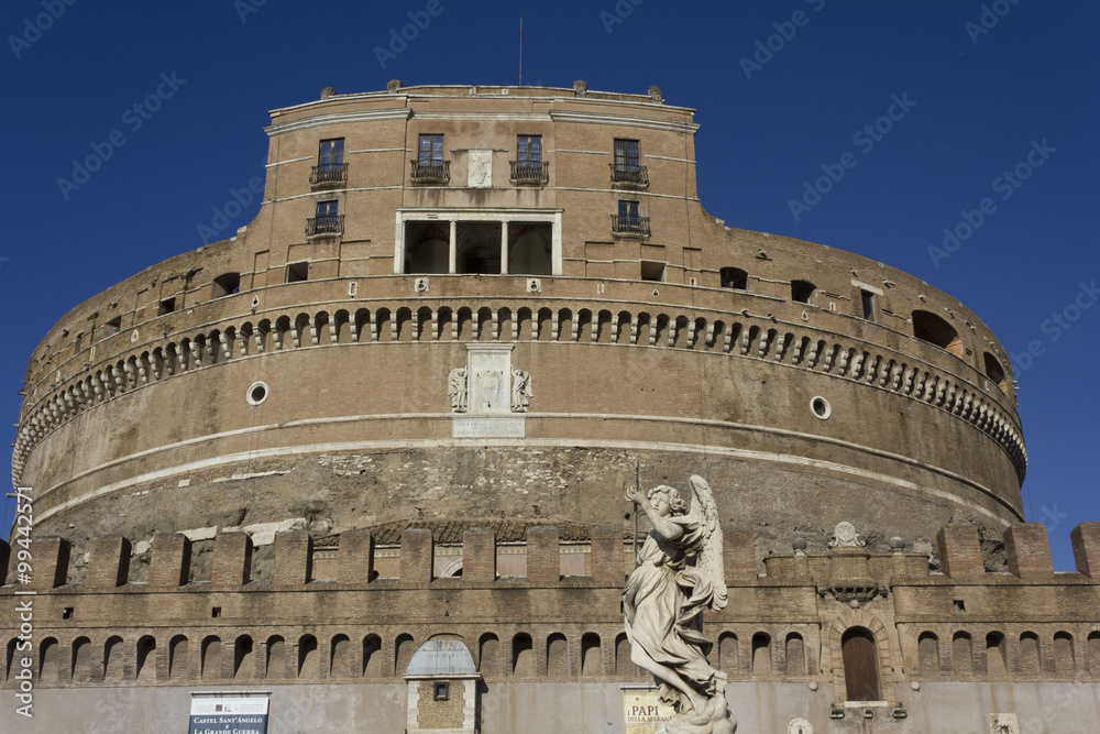 Architectural close up of Castel Sant'Angelo frontal Facade in Rome, Italy, with an angel statue in the foreground