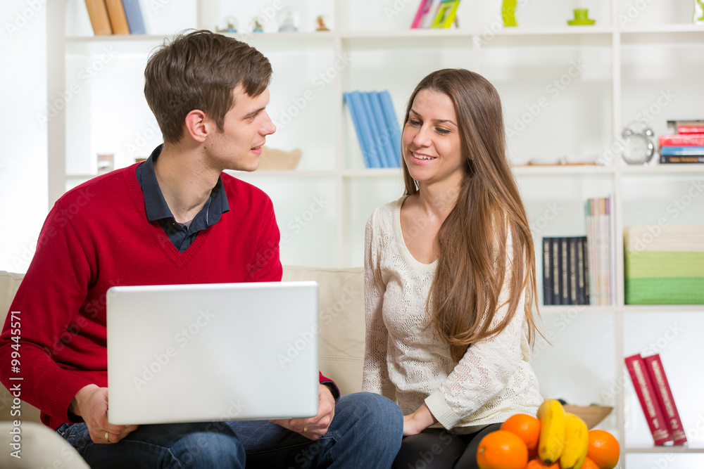 Young couple relaxing on sofa with laptop in the living room.Selective focus Young couple relaxing on sofa with laptop in the living room.Selective focus