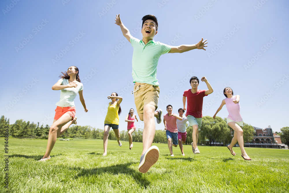 Cheerful young adults running on grass Cheerful young adults running on grass