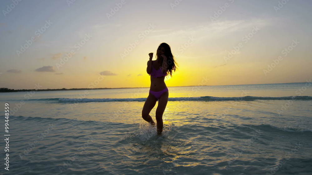 Ethnic female in swimwear on tropical ocean beach 