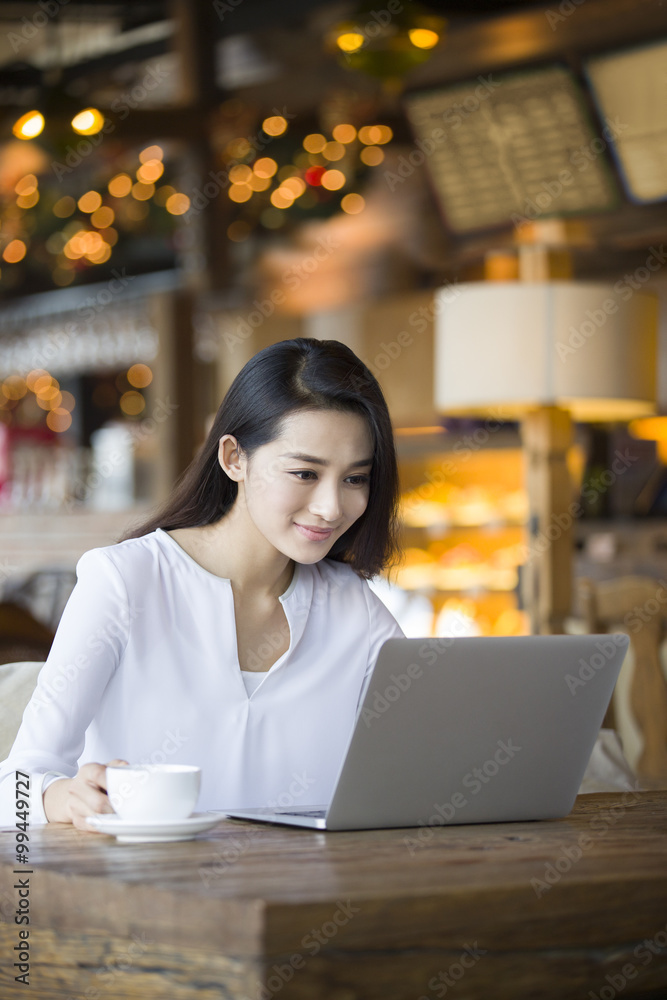 Young woman using laptop in cafe Young woman using laptop in cafe