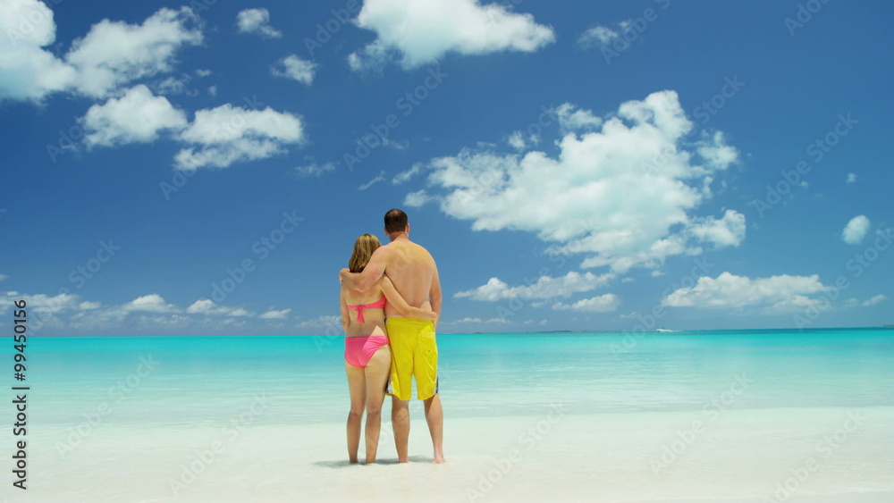 Young Caucasian couple in swimwear on a luxury beach vacation Young Caucasian couple in swimwear on a luxury beach vacation