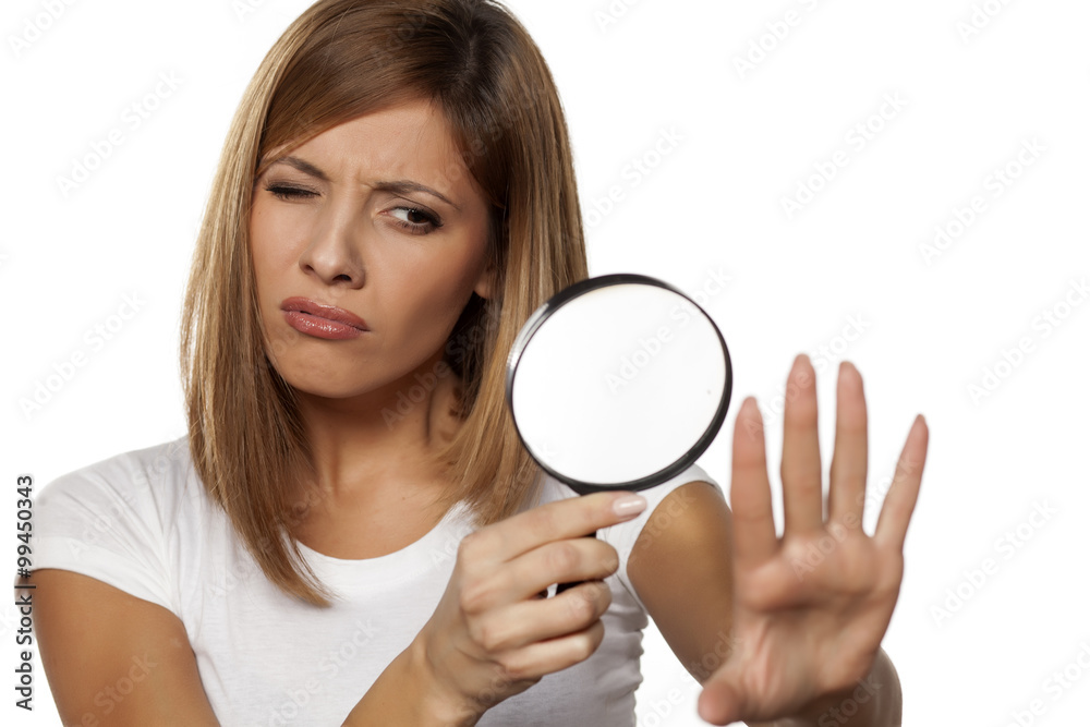 beautiful young woman analyze her nails with a magnifying glass beautiful young woman analyze her nails with a magnifying glass