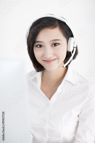 Cheerful businesswoman with headset in office