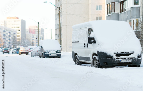 Cars covered with snow on the street in winter. © M-Production
