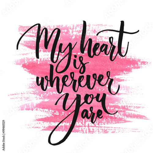 My heart is wherever you are. Romantic quote for Valentines day cards and prints. Black ink calligraphy at pink watercolor texture.