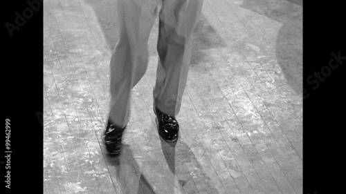 Low section of male tap dancer dancing on wooden floor, 1950s