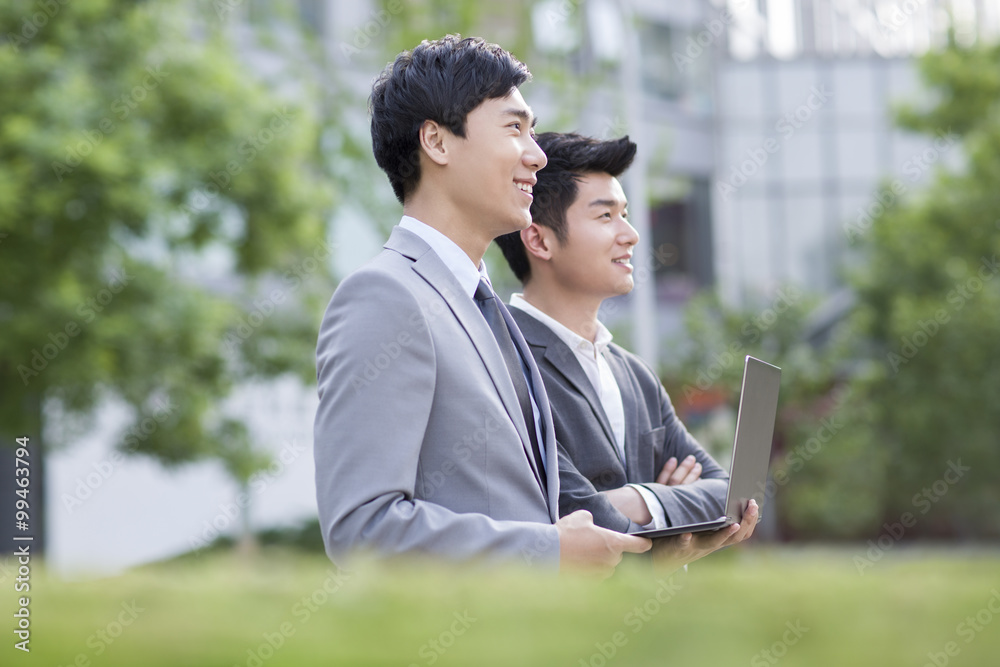 Young business person working with laptop outdoors Young business person working with laptop outdoors