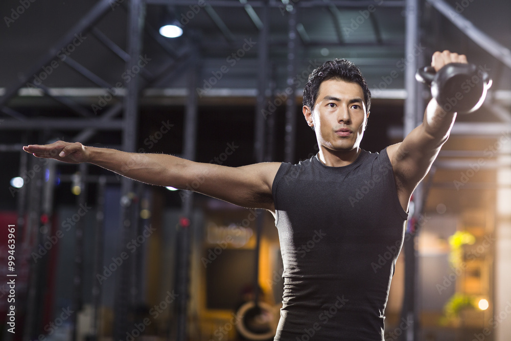 Young man training with kettlebell in crossfit gym Young man training with kettlebell in crossfit gym