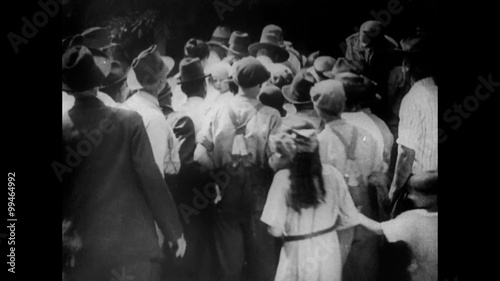 Rear view of large group of people assembling outdoors, 1920s photo
