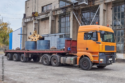 Cranes unloading a freight transport with still rolls