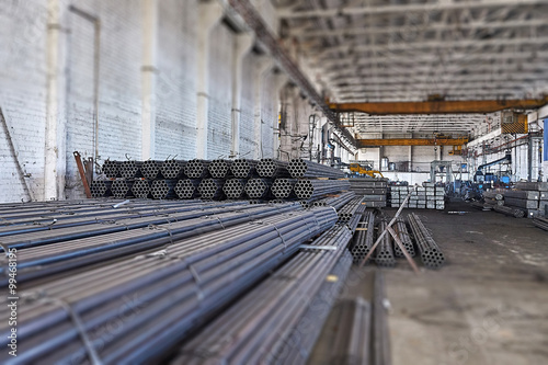 Metal pipes in a warehouse. Stacks of new round steel pipe in fa