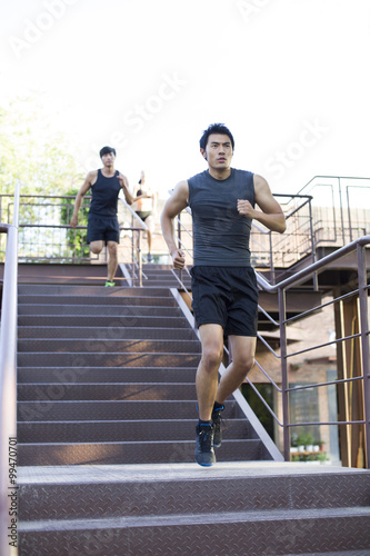 Young joggers running down steps outdoors