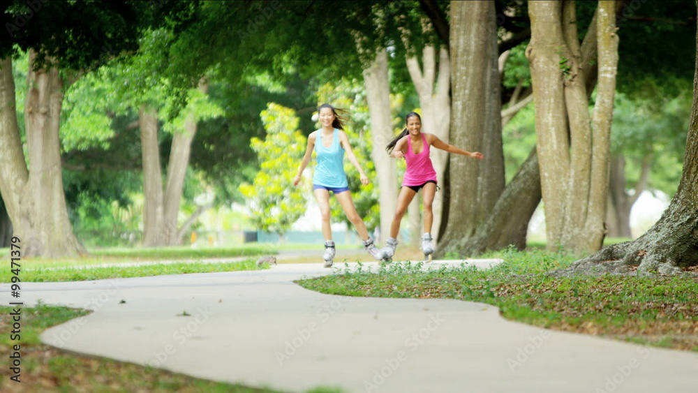 Young active multi ethnic American girls roller skating outdoor Young active multi ethnic American girls roller skating outdoor