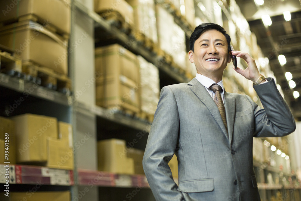 Businessman on the phone in warehouse Businessman on the phone in warehouse