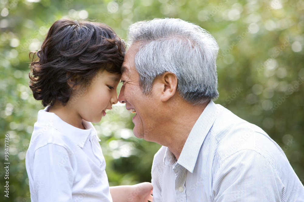 Grandfather with his grandson smiling outdoors Grandfather with his grandson smiling outdoors