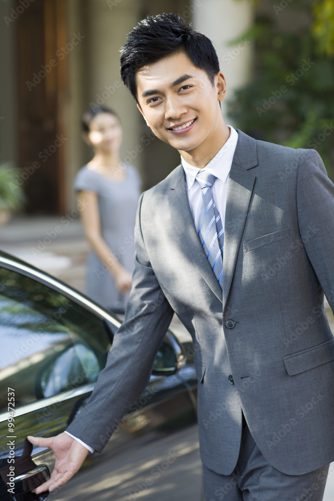 Young businessman opening car door Young businessman opening car door
