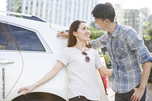 Happy young couple and car