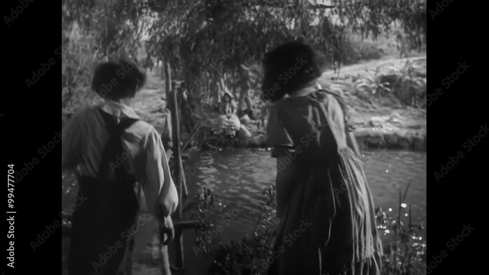 Young boy and girl walking next to river, 1940s Young boy and girl walking next to river, 1940s