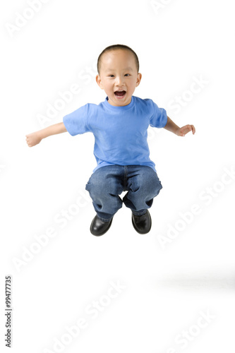 young boy jumps in the air