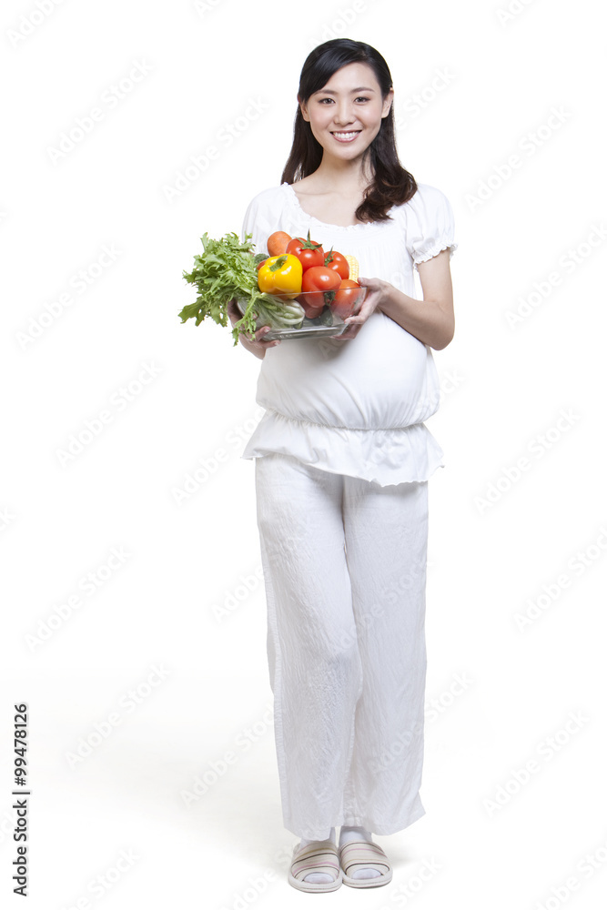 Pregnant woman holding a bowl of fresh vegetables Pregnant woman holding a bowl of fresh vegetables