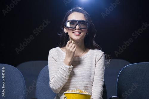 Young woman watching 3D movie in cinema photo