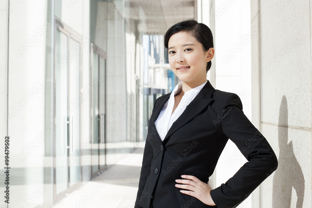 Portrait of young businesswoman hand on hip in downtown district Portrait of young businesswoman hand on hip in downtown district