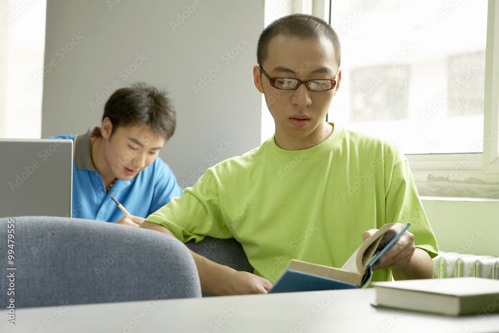 Student Sitting And Reading A Book Student Sitting And Reading A Book