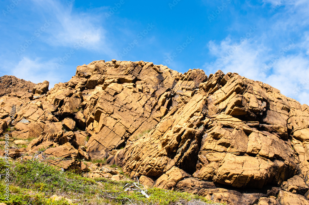 Ταπετσαρία Large irregular cracked rock outcrop against sky