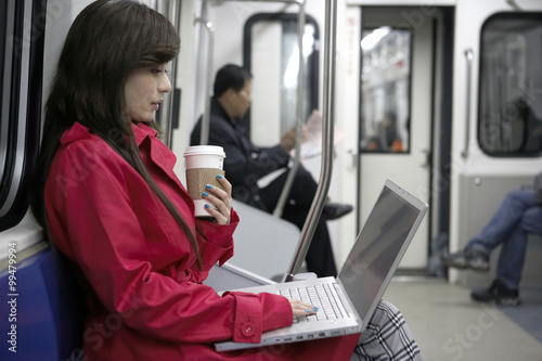 Woman Sitting On Train Typing On Laptop 