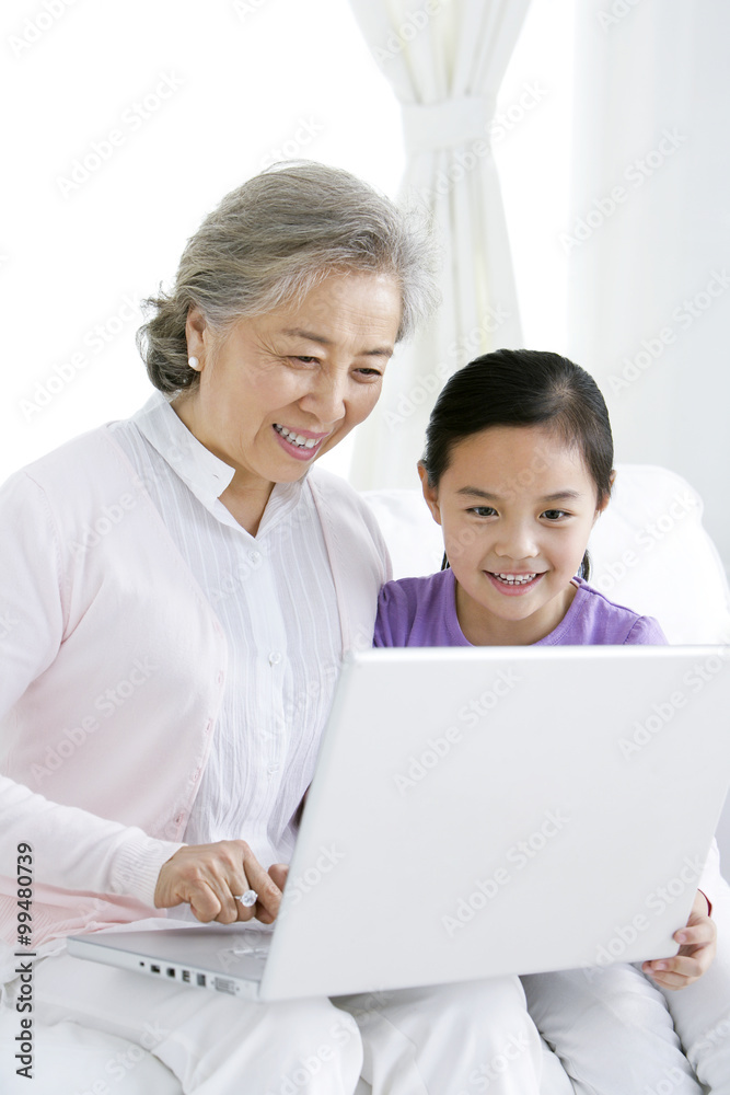 Chinese grandmother with grandaughter using a laptop Chinese grandmother with grandaughter using a laptop