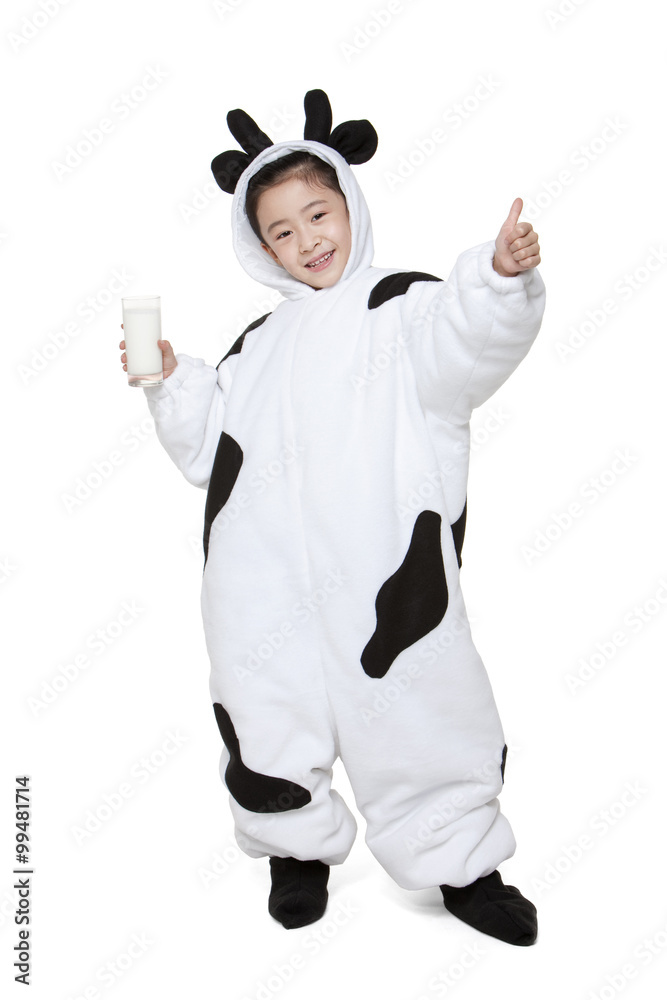 Cute girl in a cow costume with a glass of milk giving the thumbs-up sign