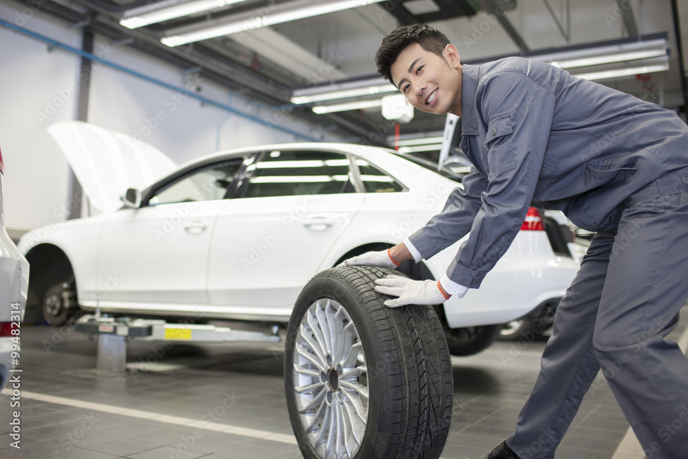 Auto mechanic rolling tire Auto mechanic rolling tire