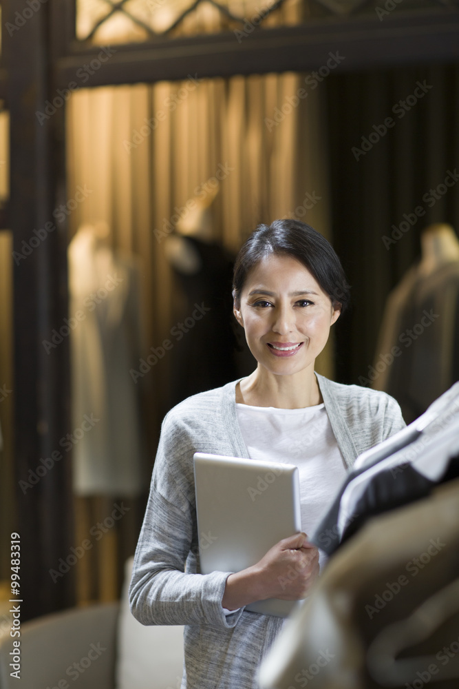 Clothing store owner with digital tablet