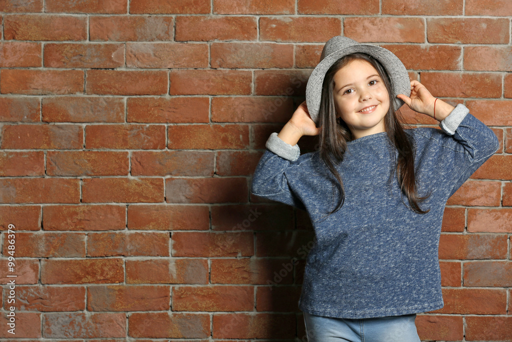Portrait of little fashion kid girl on bricks wall background Portrait of little fashion kid girl on bricks wall background