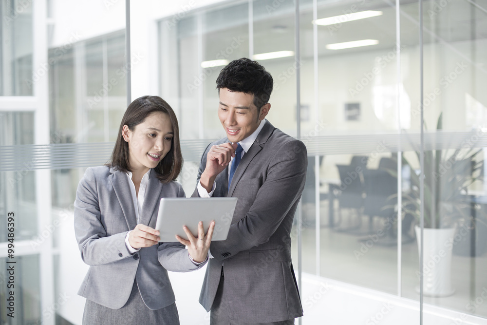Business person looking at digital tablet together Business person looking at digital tablet together