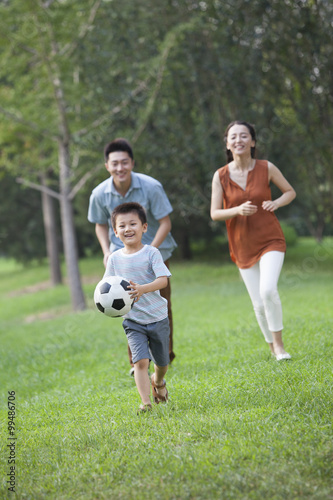 Happy young family playing football © Blue Jean Images