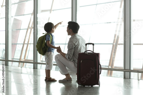 Father and son looking at view at the airport