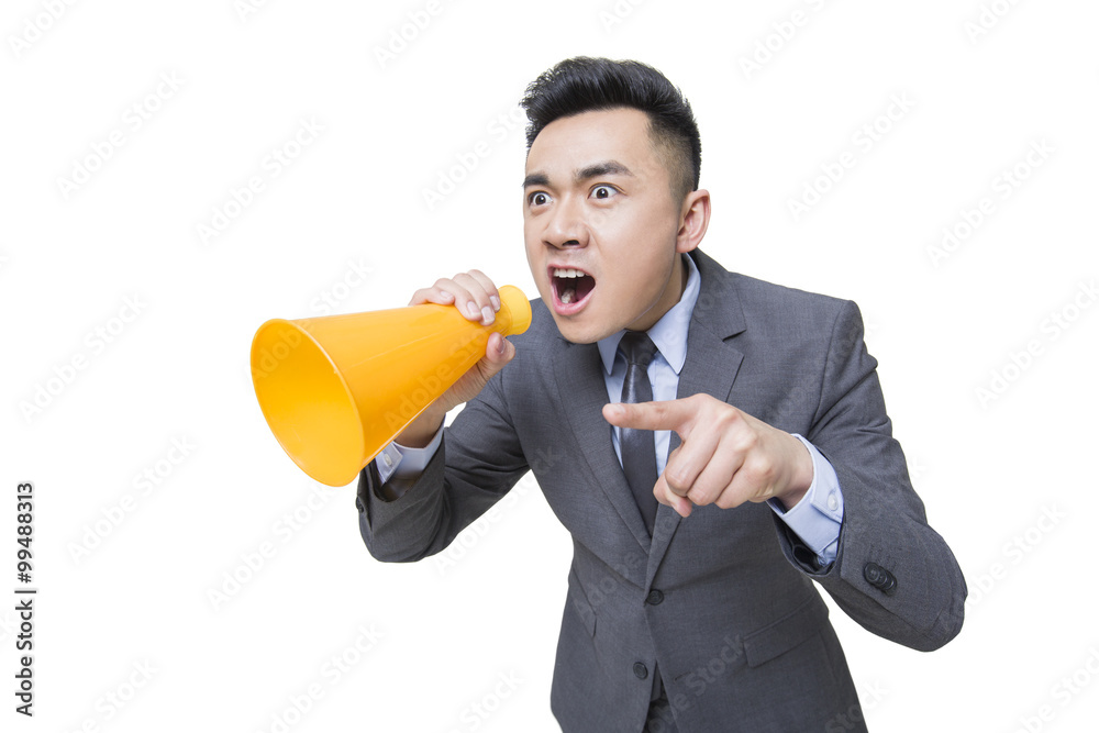 Young businessman shouting into megaphone Young businessman shouting into megaphone