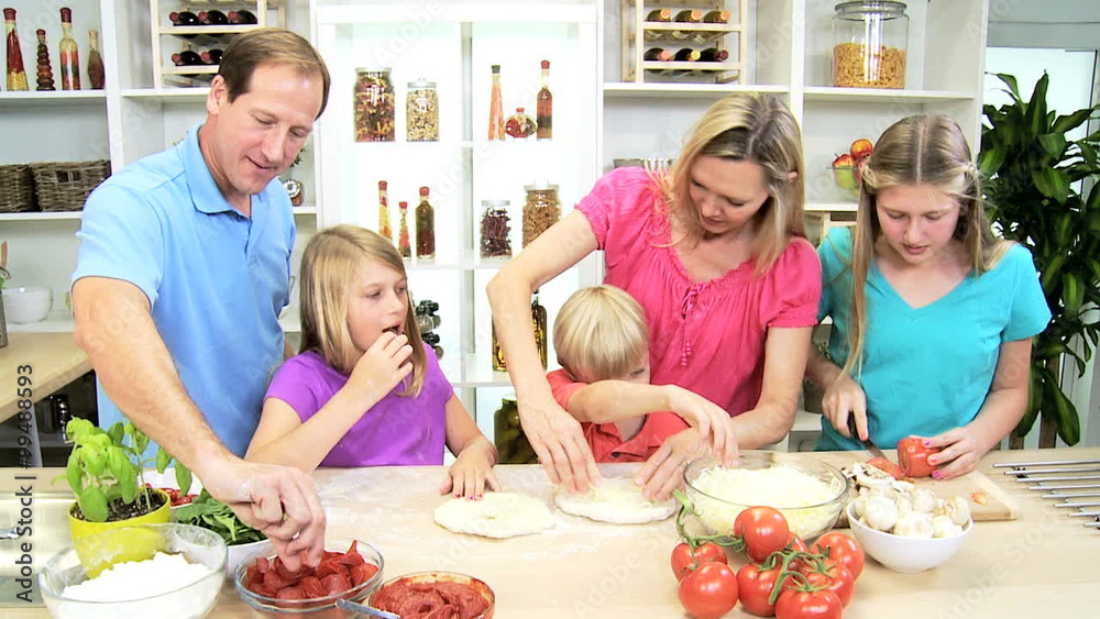 Caucasian family male female parents children fresh health eating homemade pizza Caucasian family male female parents children fresh health eating homemade pizza