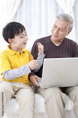 Grandpa and grandson using laptop