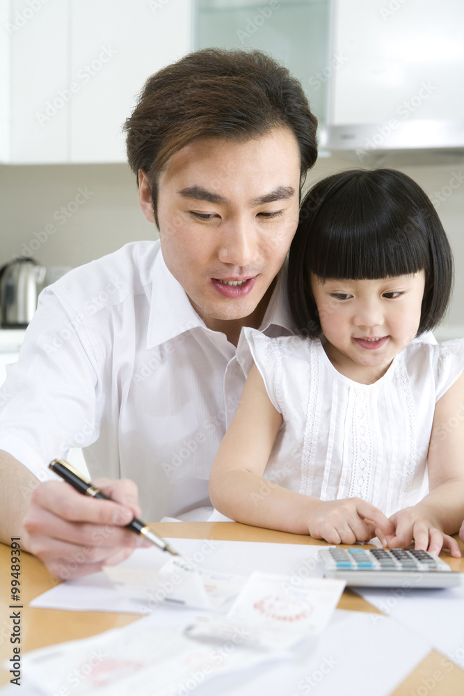 Father and daughter doing the household accounting Father and daughter doing the household accounting